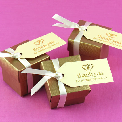 Ivory and Gold Favor Cards attached to gold favor boxes.