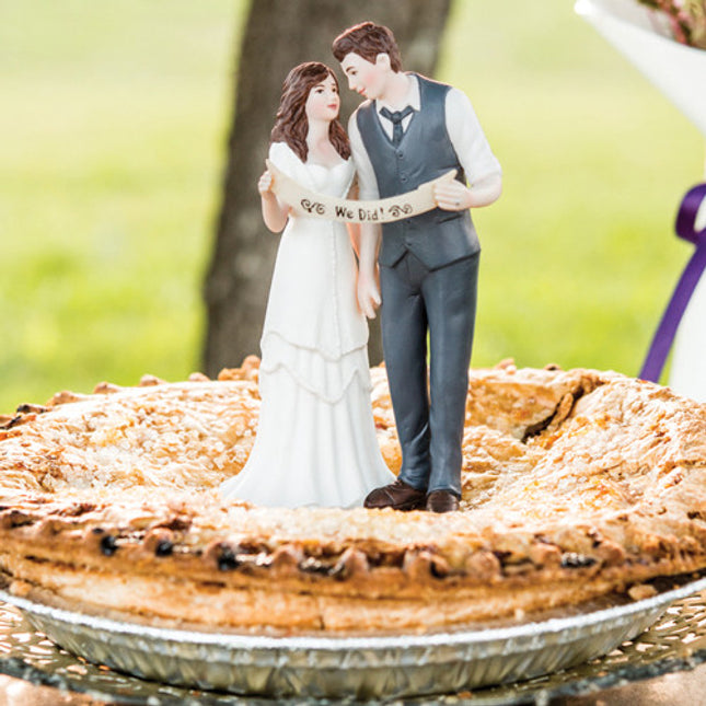 A cute Indie Wedding Couple Porcelain Cake Top on top of a blueberry pie.